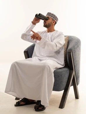 رجل عماني بالمنظار يرتدي الملابس التقليدية
