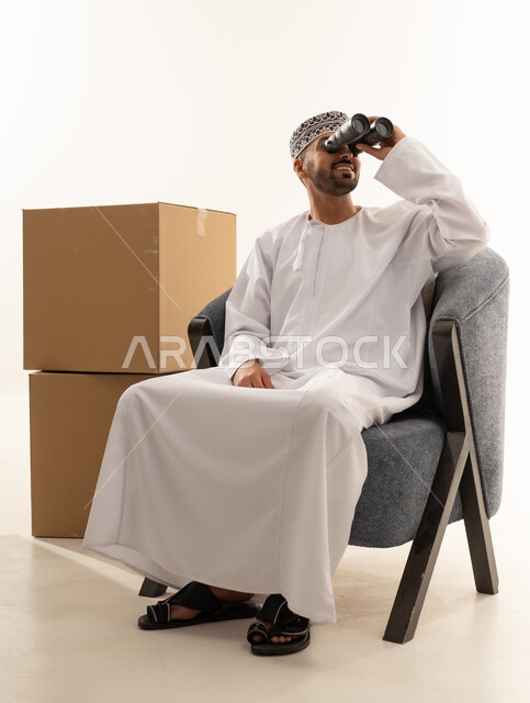 Omani Man with Binoculars and Shipping Boxes
