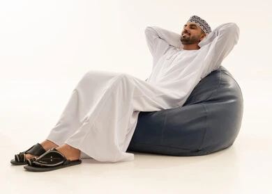 Omani Man in Traditional Dress Relaxing on Bean Bag