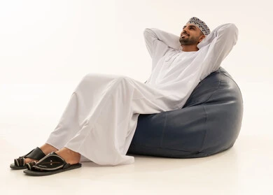 Omani Man in Traditional Dress Relaxing on Bean Bag