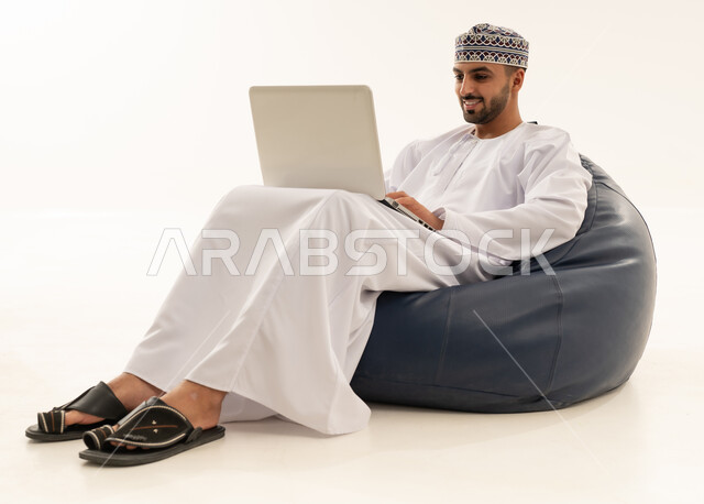 رجل عماني بالزي التقليدي يستخدم المحمول في الاستوديو