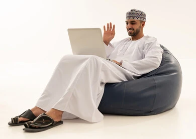 Omani Man on Laptop Video Call in Traditional Dress