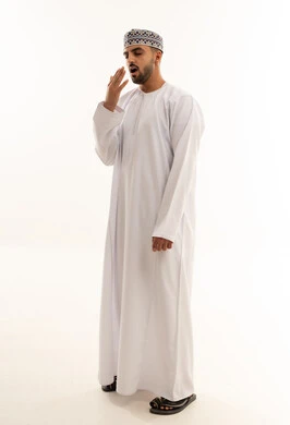 رجل عماني يتثاءب بالزي العماني التقليدي