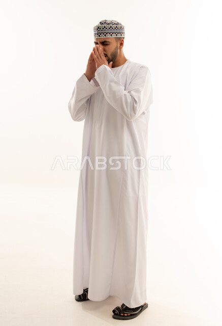 Omani Man in Traditional Dress Praying on White Background