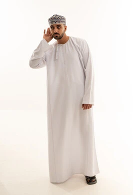 رجل عماني بالدشداشة التقليدية والكمة في وضعية الاستماع