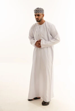 رجل عماني بالدشداشة التقليدية يعاني من ألم في البطن