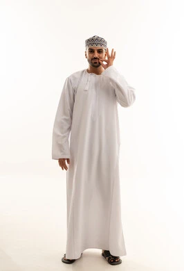 رجل عُماني بالزي التقليدي يشير بعلامة الرضا