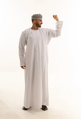 رجل عماني بالزي التقليدي يستعرض عضلاته في الاستوديو