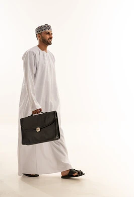 Omani Man in Traditional Dress Walking with Briefcase