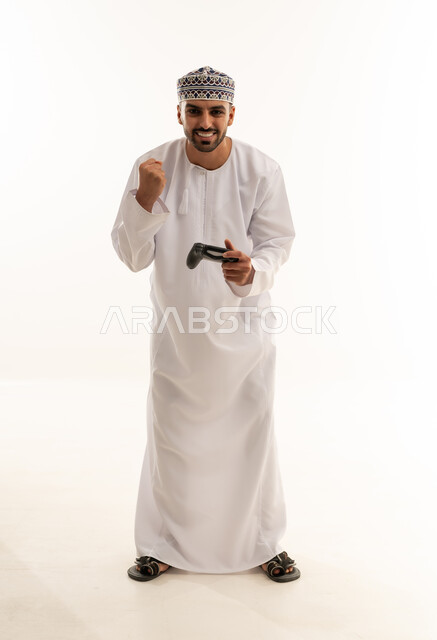 رجل عماني بالزي التقليدي يلعب ألعاب الفيديو