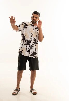 رجل عربي بملابس صيفية مع إيماءات يد أمام خلفية بيضاء