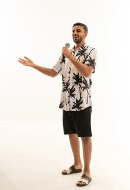 رجل خليجي يتحدث في الميكروفون أمام خلفية بيضاء