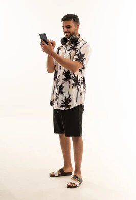 Arab Man Using Smartphone with Headphones on White Background