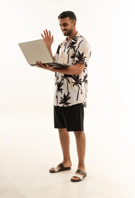 Arab Man in Summer Clothes Using Laptop on White Background