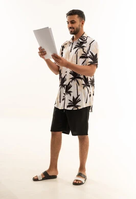Saudi Man in Summer Shirt Reading Documents in Studio