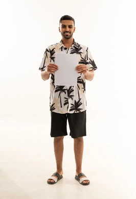 شاب سعودي يحمل لوحة بيضاء فارغة في الاستديو