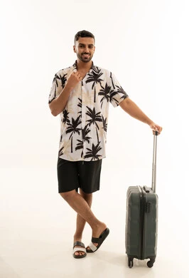 مسافر عربي مع حقيبة بملابس صيفية