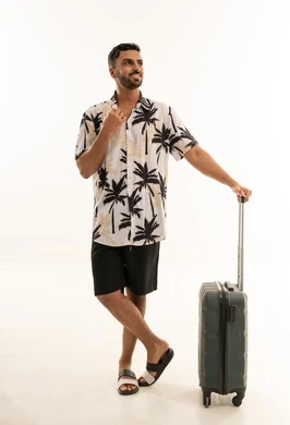 رجل سعودي مع حقيبة سفر بملابس صيفية