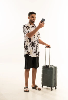 مسافر سعودي مع حقيبة سفر وهاتف ذكي