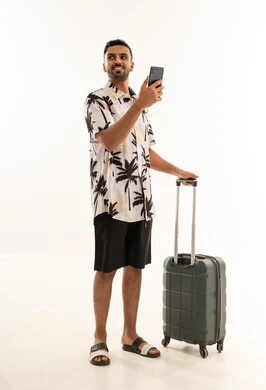رجل عربي مع حقيبة سفر وهاتف ذكي بمفهوم السياحة والرحلات
