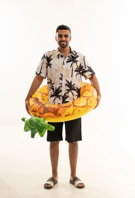 رجل سعودي بقميص استوائي مع عوامة سباحة أناناس