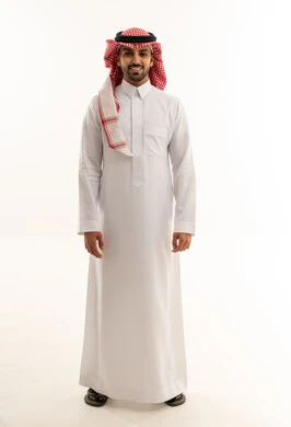 رجل سعودي بالزي التقليدي والشماغ يقف في الاستوديو