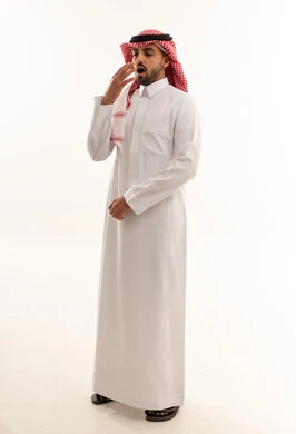 رجل سعودي بالزي التقليدي يتثاءب أمام خلفية بيضاء