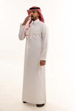 رجل سعودي بالزي التقليدي يتثاءب أمام خلفية بيضاء