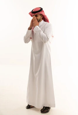 رجل سعودي بالثوب التقليدي أمام خلفية بيضاء