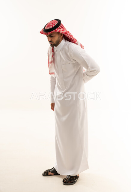 رجل سعودي يعاني من ألم في الظهر بالزي التقليدي