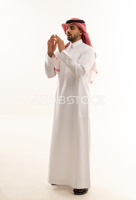 رجل سعودي بالثوب التقليدي يدعو في استوديو