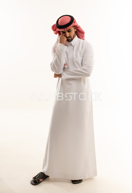 رجل سعودي بالزي التقليدي في وضعية تفكير