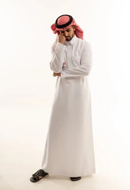 رجل سعودي بالزي التقليدي في وضعية تفكير