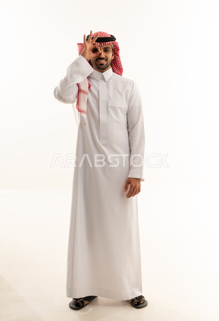رجل سعودي بالزي التقليدي مع إشارة اليد