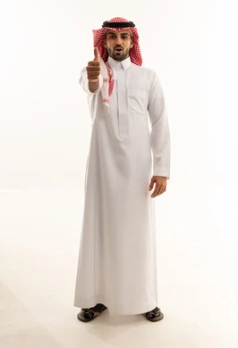 رجل سعودي بالثوب يرفع إبهامه على خلفية بيضاء
