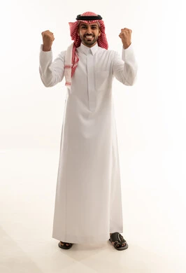 رجل سعودي يحتفل بالنجاح بالزي التقليدي الرسمي