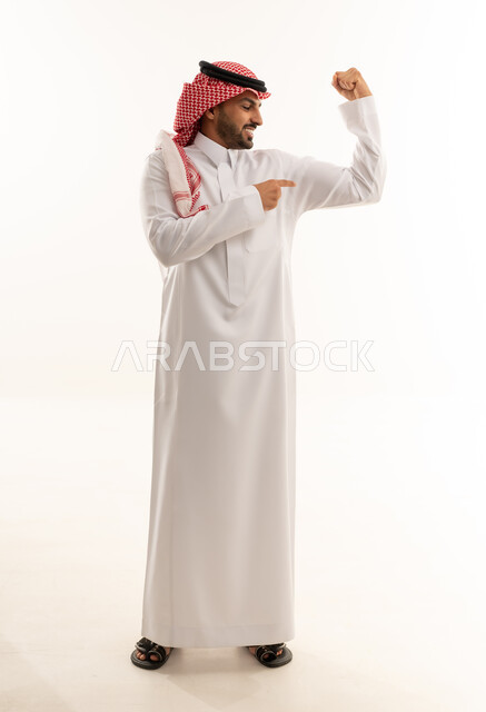 رجل سعودي بالثوب التقليدي يستعرض عضلاته