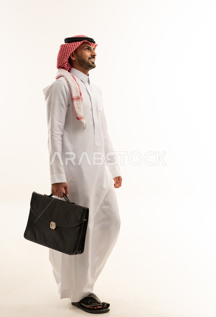 رجل أعمال سعودي بالزي التقليدي يحمل حقيبة عمل