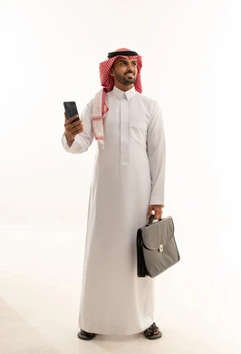 رجل أعمال سعودي مع حقيبة وهاتف ذكي