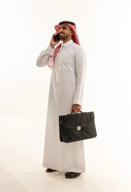 رجل أعمال سعودي مع حقيبة يتحدث بالهاتف