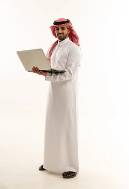 رجل سعودي بالثوب التقليدي يحمل جهاز محمول