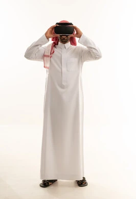 رجل سعودي بالزي التقليدي يرتدي نظارة واقع افتراضي