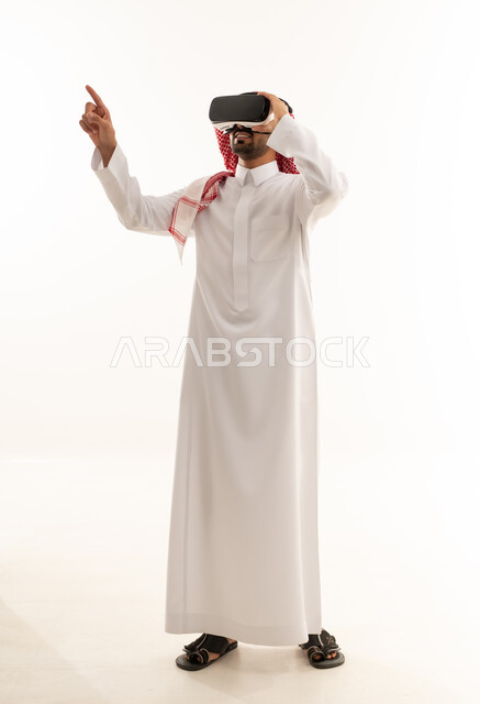 رجل سعودي يستخدم نظارات الواقع الافتراضي بخلفية بيضاء