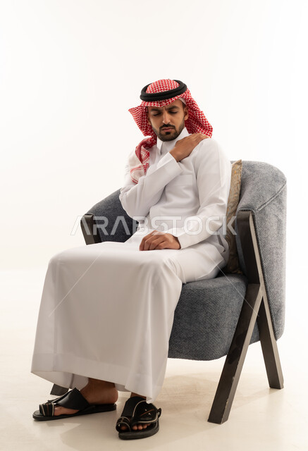 رجل سعودي بالزي التقليدي يعاني من ألم الكتف