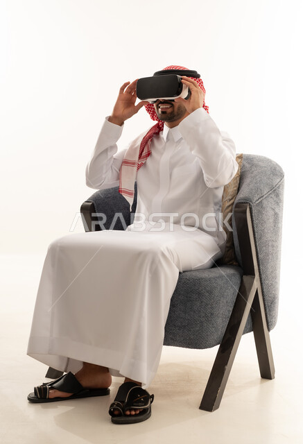 رجل سعودي يستخدم نظارة الواقع الافتراضي بالزي التقليدي