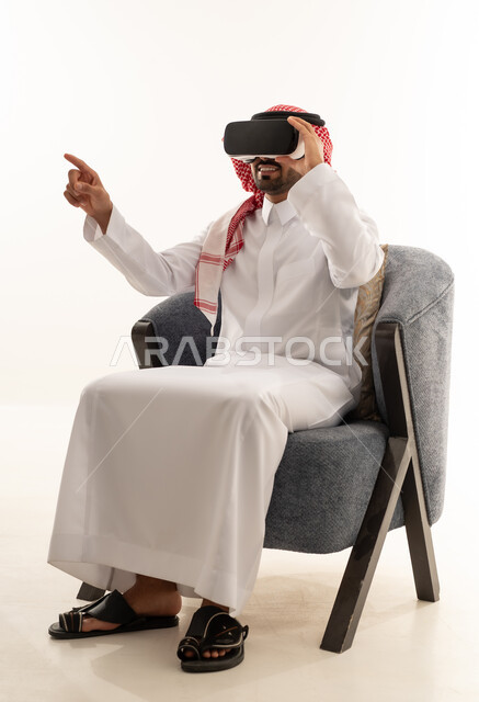 رجل سعودي يرتدي الثوب ويستخدم نظارات الواقع الافتراضي