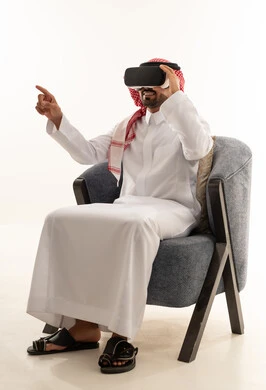 Saudi Man in Traditional Thobe Using VR Goggles