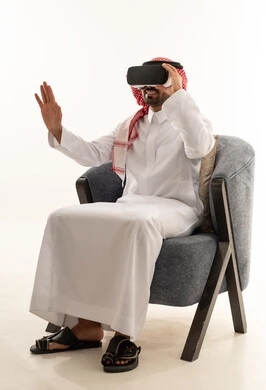 رجل سعودي يرتدي الثوب التقليدي ويستخدم نظارة الواقع الافتراضي