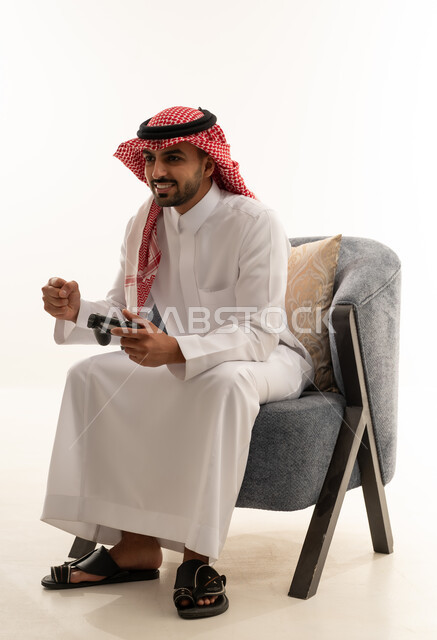 رجل سعودي يلعب ألعاب فيديو بالزي التقليدي