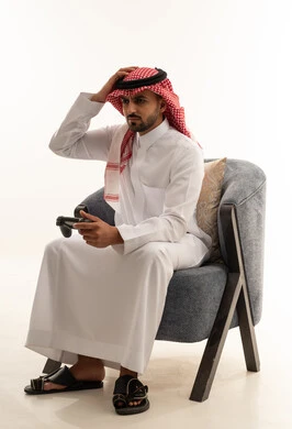 رجل سعودي يلعب ألعاب الفيديو بتعبير محبط